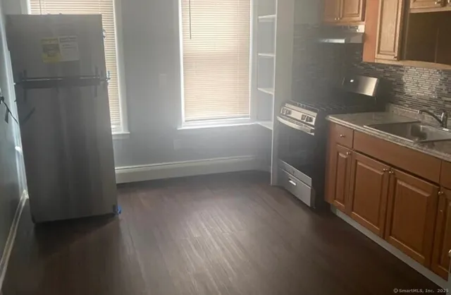 a view of a kitchen with wooden floor and electronic appliances