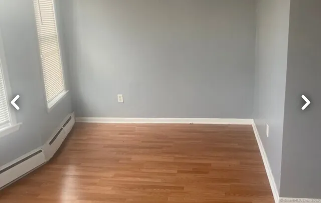 a view of a room with wooden floor and window