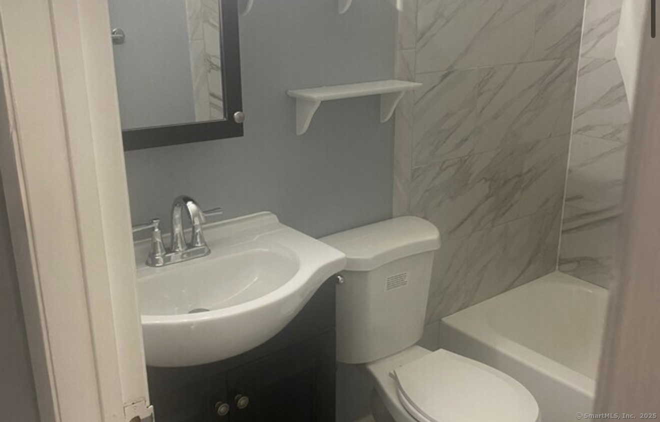 1322 Stratford Avenue Bridgeport, CT 06607 - Photo 4 of 4 a white toilet sitting next to a bathroom sink