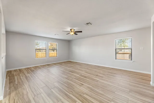 wooden floor in an empty room with a window