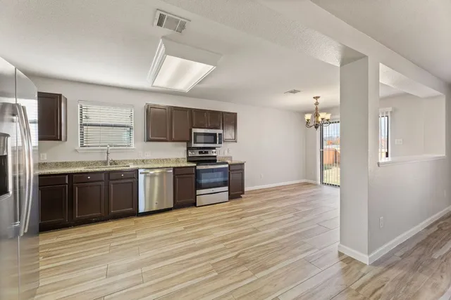 a kitchen with stainless steel appliances kitchen island granite countertop a stove cabinets and refrigerator