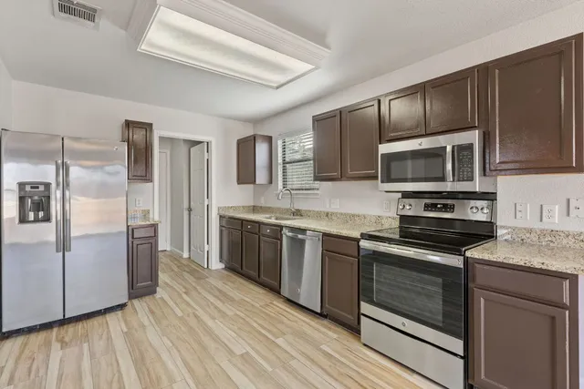 a kitchen with stainless steel appliances granite countertop a stove microwave and refrigerator