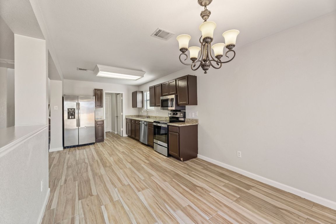 2009 Perkins Place Georgetown, TX 78626 - Photo 18 of 36 a kitchen with stainless steel appliances granite countertop a dishwasher a stove top oven a sink dishwasher and wooden floor