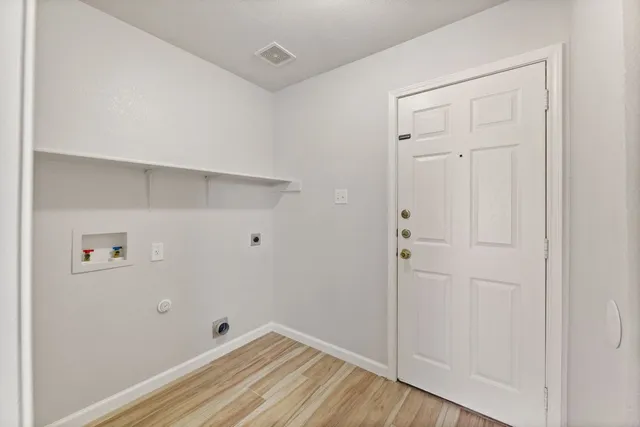a view of a room with wooden floor fan and windows