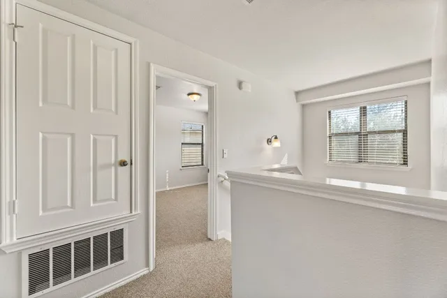 a view of hallway with closet and mirror