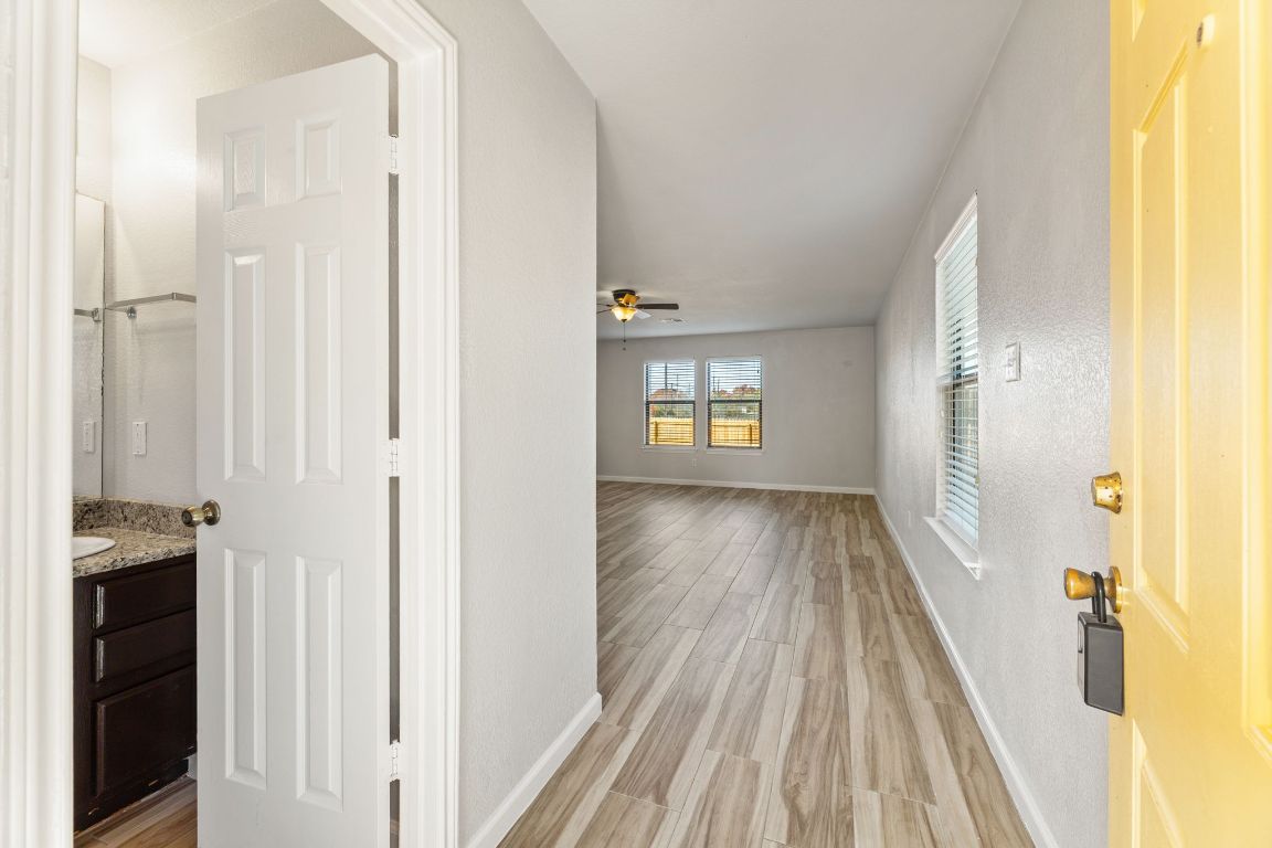 2009 Perkins Place Georgetown, TX 78626 - Photo 5 of 36 a view of a hallway with wooden floor and a bathroom