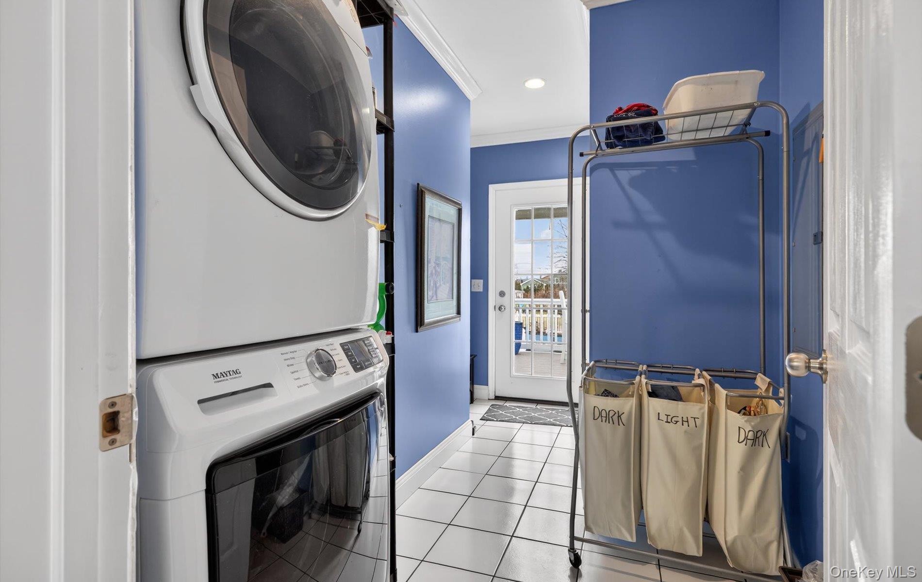 108 Awixa Avenue Bay Shore, NY 11706 - Photo 27 of 47 Laundry area with light tile patterned floors, stacked washer and dryer, crown molding, and recessed lighting