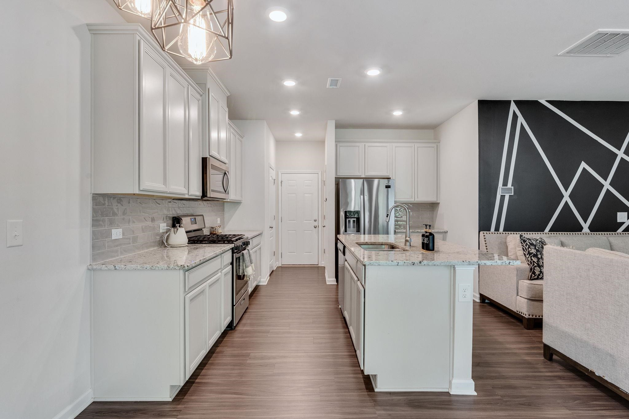 3422 Dropseed Drive Apex, NC 27502 - Photo 14 of 40 a kitchen with white cabinets and stainless steel appliances
