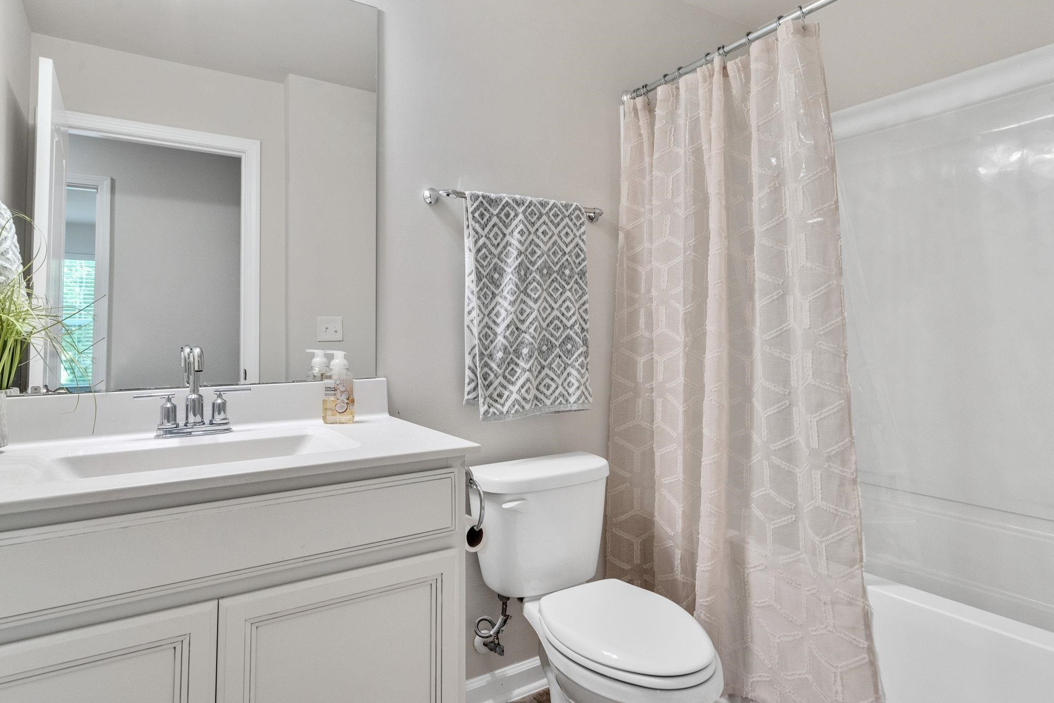 3422 Dropseed Drive Apex, NC 27502 - Photo 27 of 40 a bathroom with a sink a toilet and shower curtain