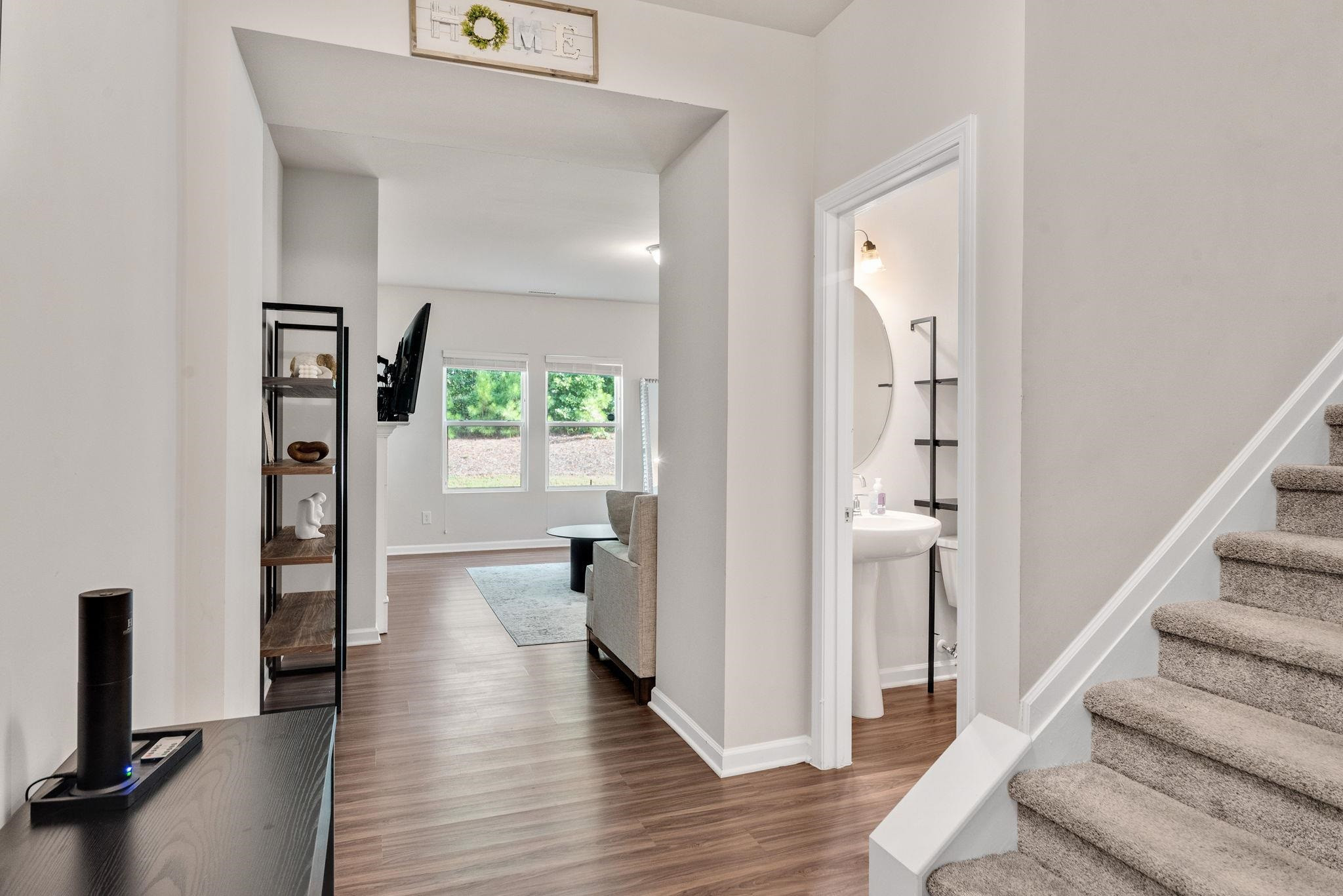 3422 Dropseed Drive Apex, NC 27502 - Photo 7 of 40 a view of a hallway with wooden floor and windows