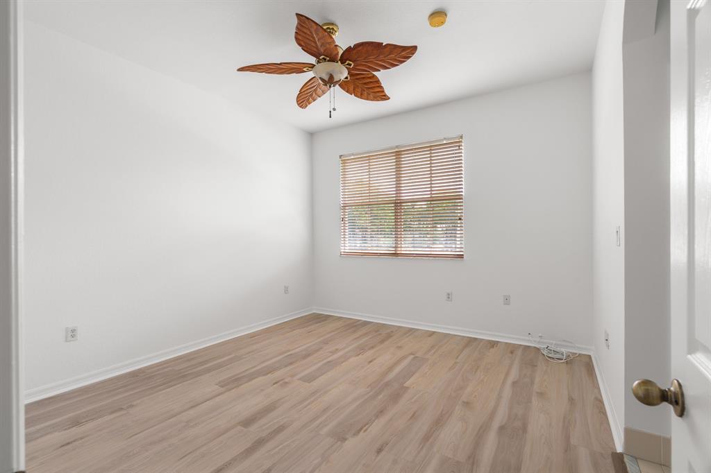3210 Merrick Terrace, Unit 1503 Margate, FL 33063 - Photo 13 of 24 an empty room with wooden floor ceiling fan and window