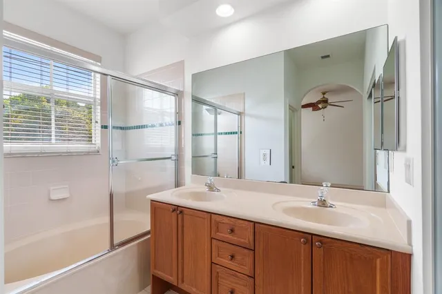 a bathroom with a double vanity sink a mirror and a bathtub