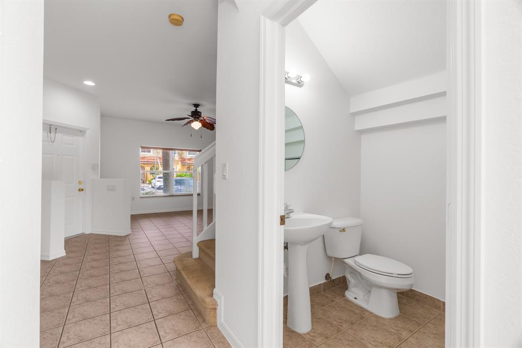 3210 Merrick Terrace, Unit 1503 Margate, FL 33063 - Photo 10 of 24 a bathroom with a toilet a sink and mirror
