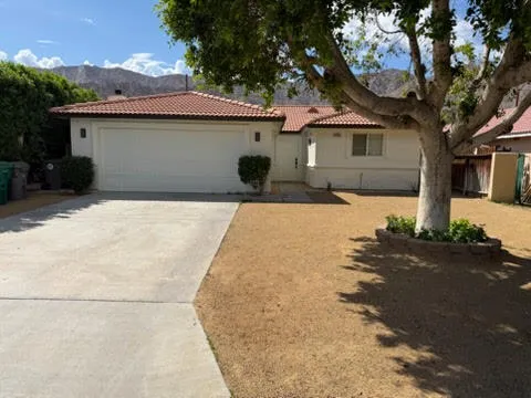 a front view of a house with yard and trees