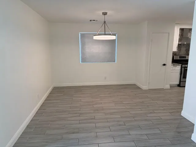 a view of a room with wooden floor and a ceiling fan