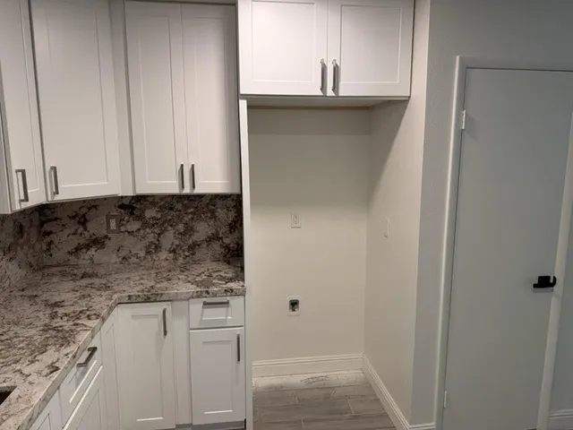 a bathroom with a granite countertop sink and cabinets