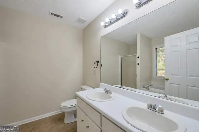 a bathroom with a sink a toilet and a mirror