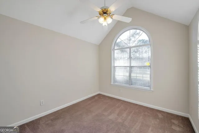 an empty room with a window a ceiling fan and a window