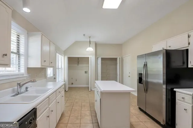 a large kitchen with a refrigerator and a sink