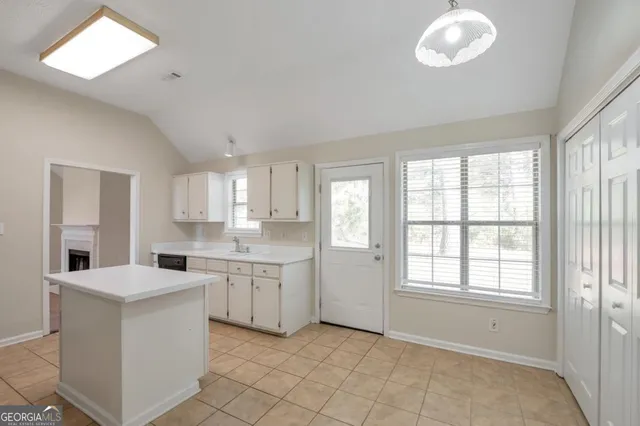 a kitchen with white cabinets and sink