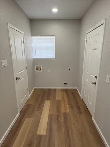 a view of a room with wooden floor and a hallway