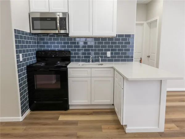 a kitchen with a sink and a stove top oven