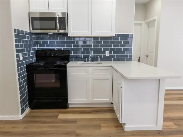 a kitchen with a sink and a stove top oven
