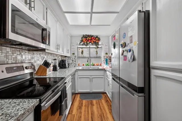 a kitchen with stainless steel appliances granite countertop a refrigerator and a stove