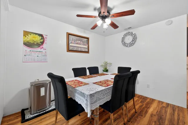 a view of a dining room with furniture and a chandelier fan