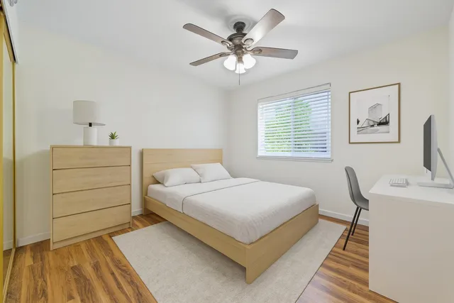 a bedroom with a bed and a table with a dresser