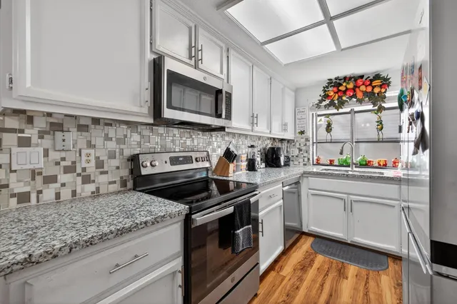 a kitchen with stainless steel appliances granite countertop a stove and a microwave