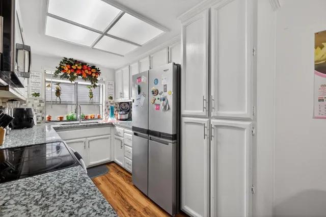 a kitchen with stainless steel appliances granite countertop a refrigerator and a sink