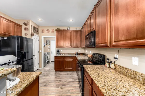 a kitchen with stainless steel appliances granite countertop wooden cabinets a stove top oven a sink and dishwasher