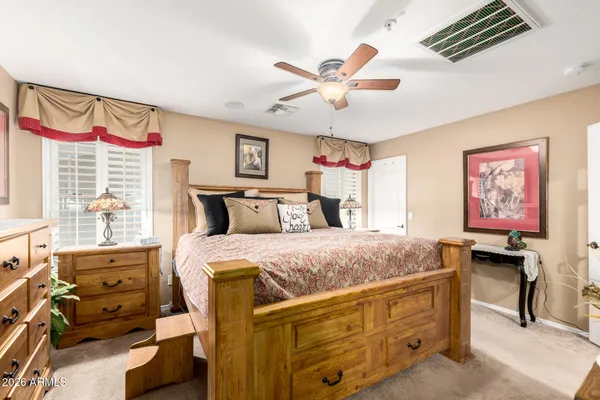 a spacious bedroom with a bed and a chandelier