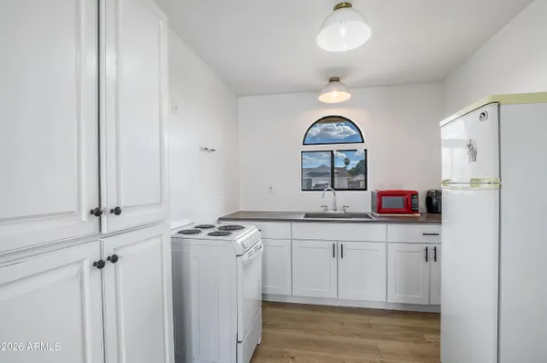an empty room with wooden floor closet and windows