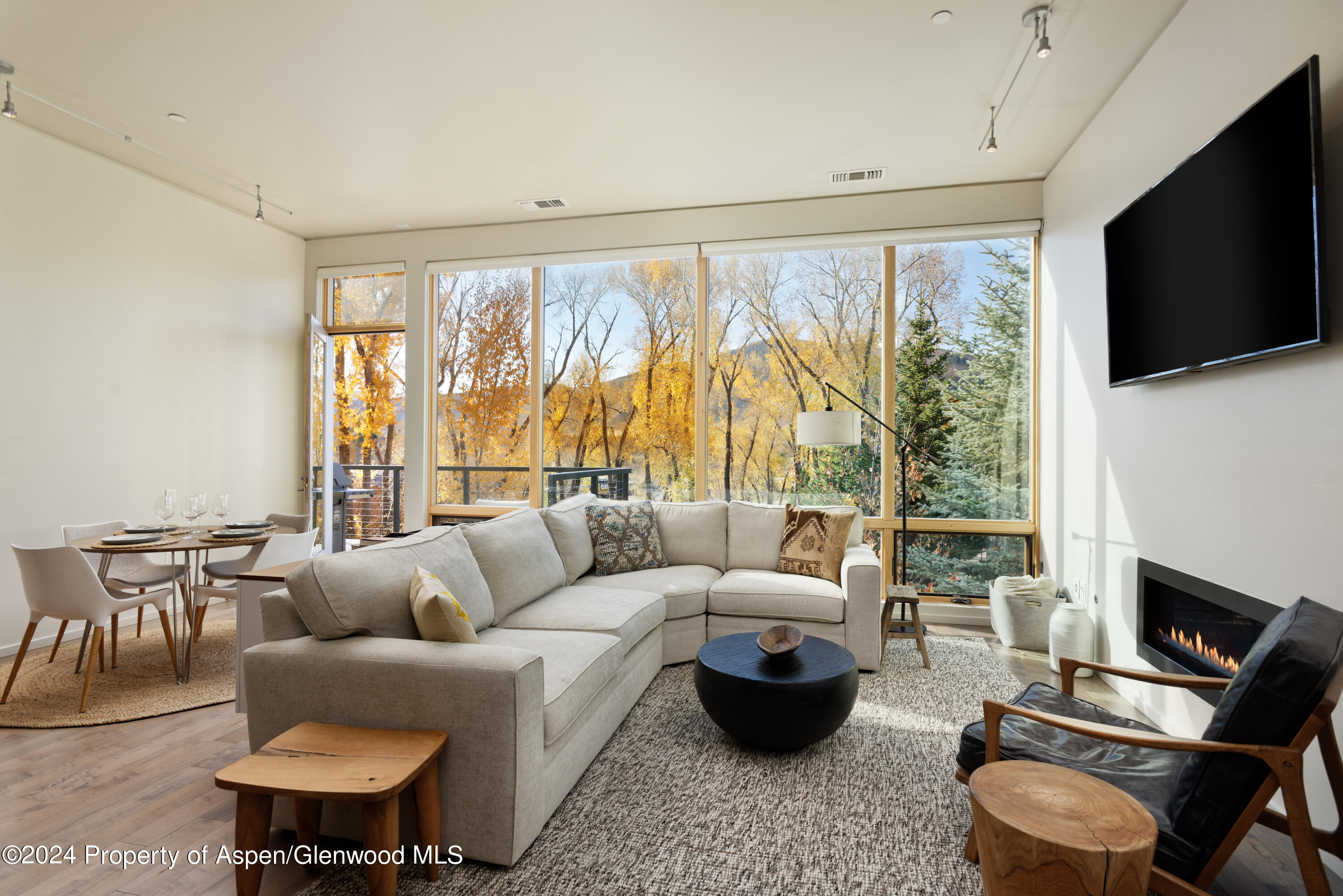 a living room with furniture a flat screen tv and a large window