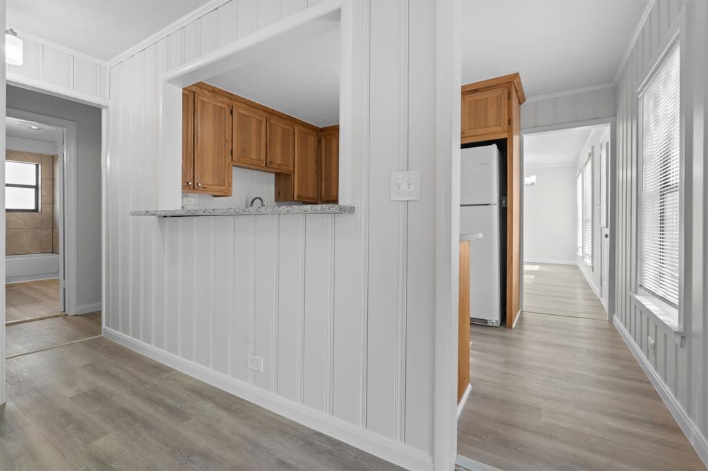 217 Clinton Drive Weatherford, TX 76086 - Photo 7 of 19 a view of a hallway with wooden floor and a cabinet