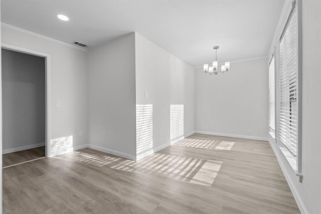 217 Clinton Drive Weatherford, TX 76086 - Photo 9 of 19 an empty room with wooden floor and chandelier