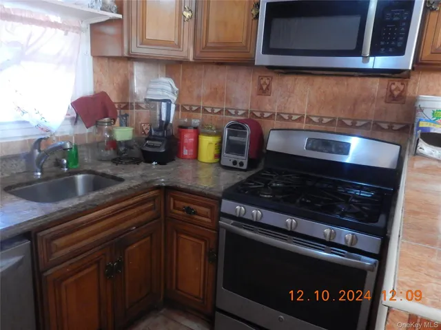a kitchen with granite countertop a stove sink and cabinets