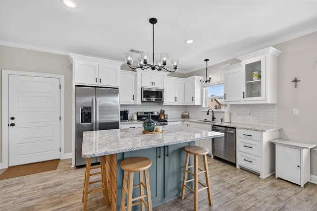 a kitchen with stainless steel appliances granite countertop a stove refrigerator and cabinets