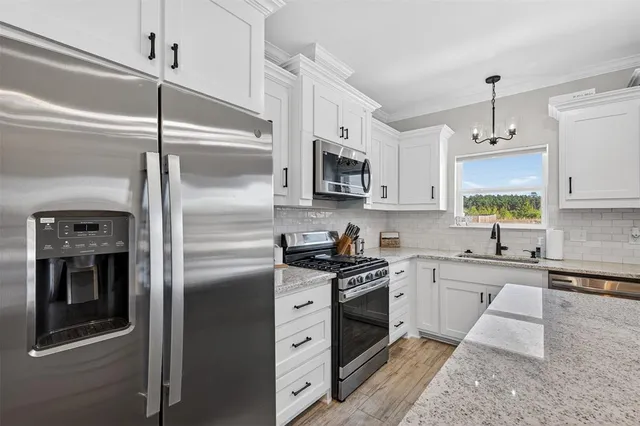 a kitchen with kitchen island a sink stainless steel appliances and cabinets