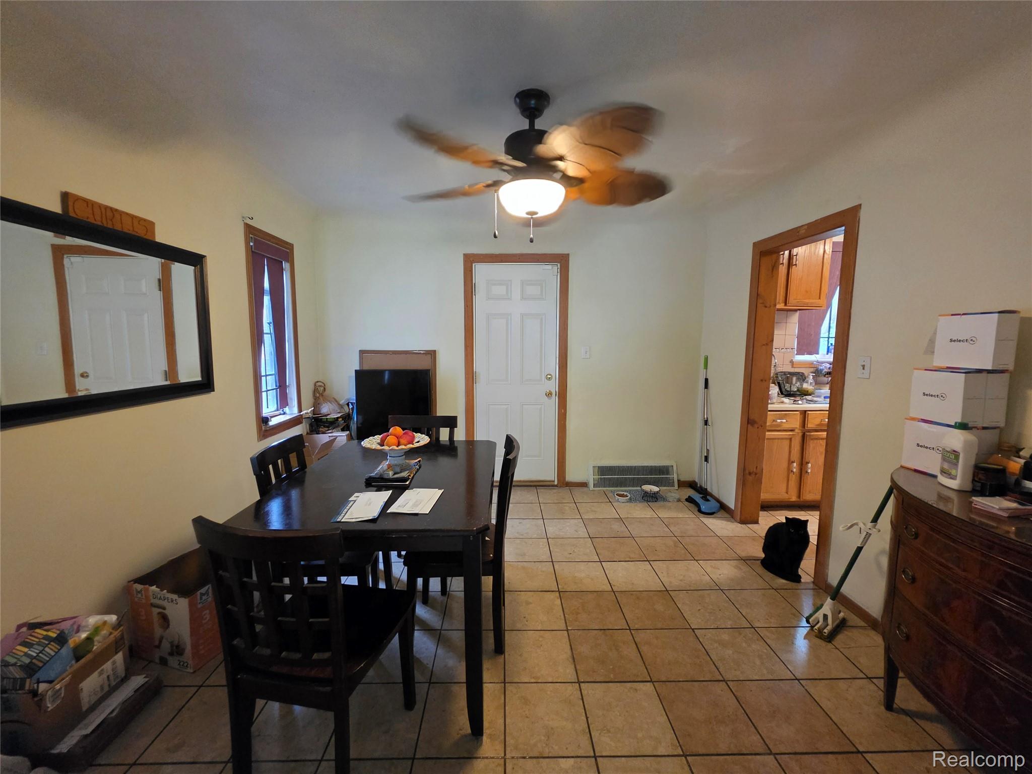 15832 Griggs Street Detroit, MI 48238 - Photo 10 of 24 Dining space with tile flooring, a ceiling fan with integrated lighting, and a doorway opening to a kitchen featuring wood cabinetry