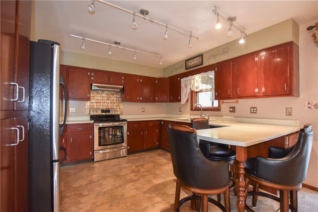 219 A Meridian Road Butler, PA 16001 - Photo 9 of 43 a kitchen with stainless steel appliances granite countertop a table chairs refrigerator and microwave