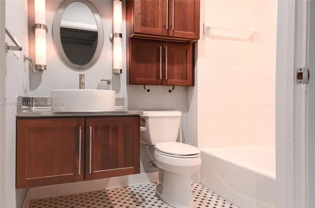 a bathroom with a toilet a sink and mirror