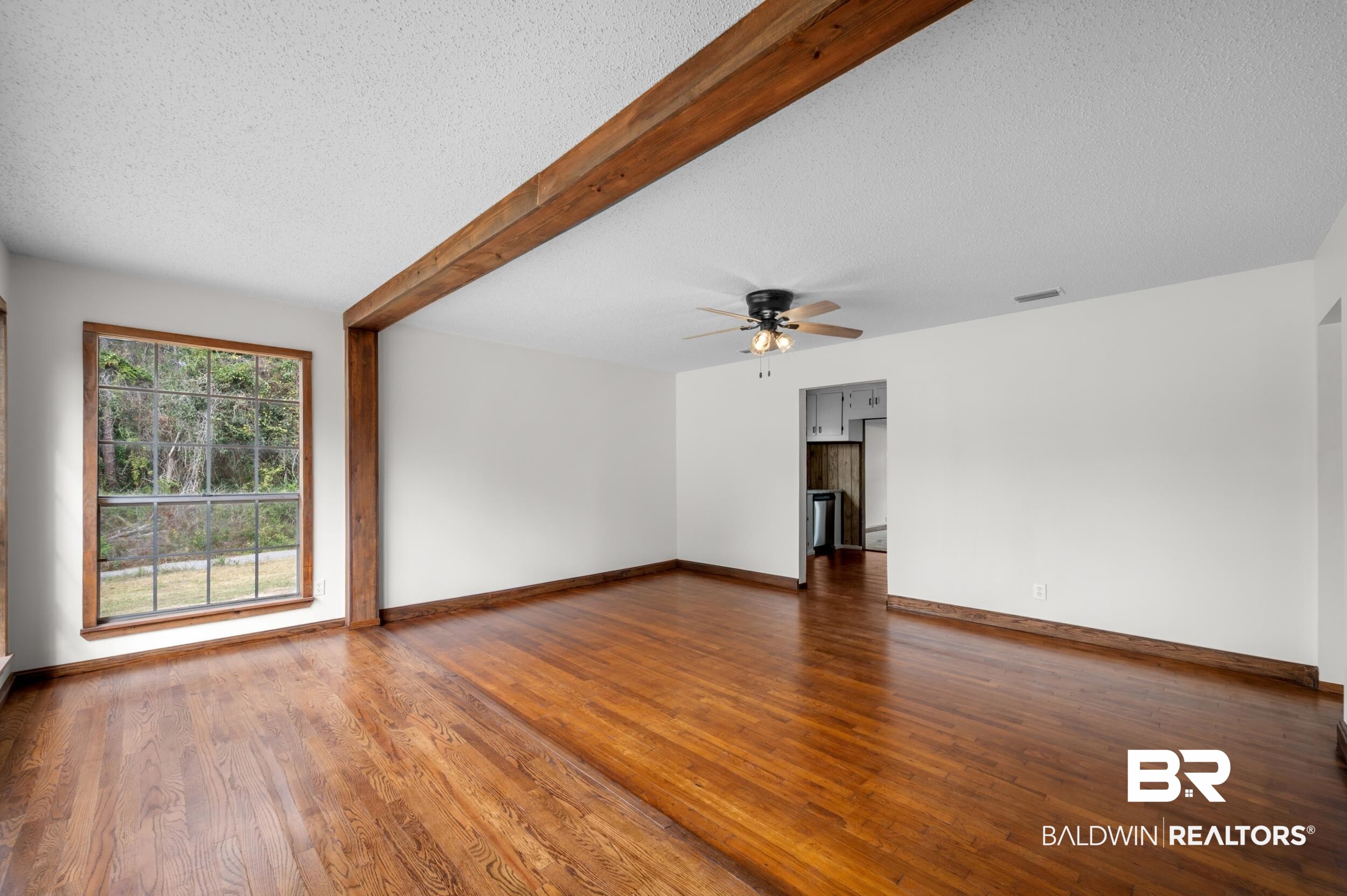 35780 Spring Road North Stapleton, AL 36578 - Photo 11 of 41 Spare room featuring beamed ceiling, a textured ceiling, hardwood / wood-style floors, and a ceiling fan