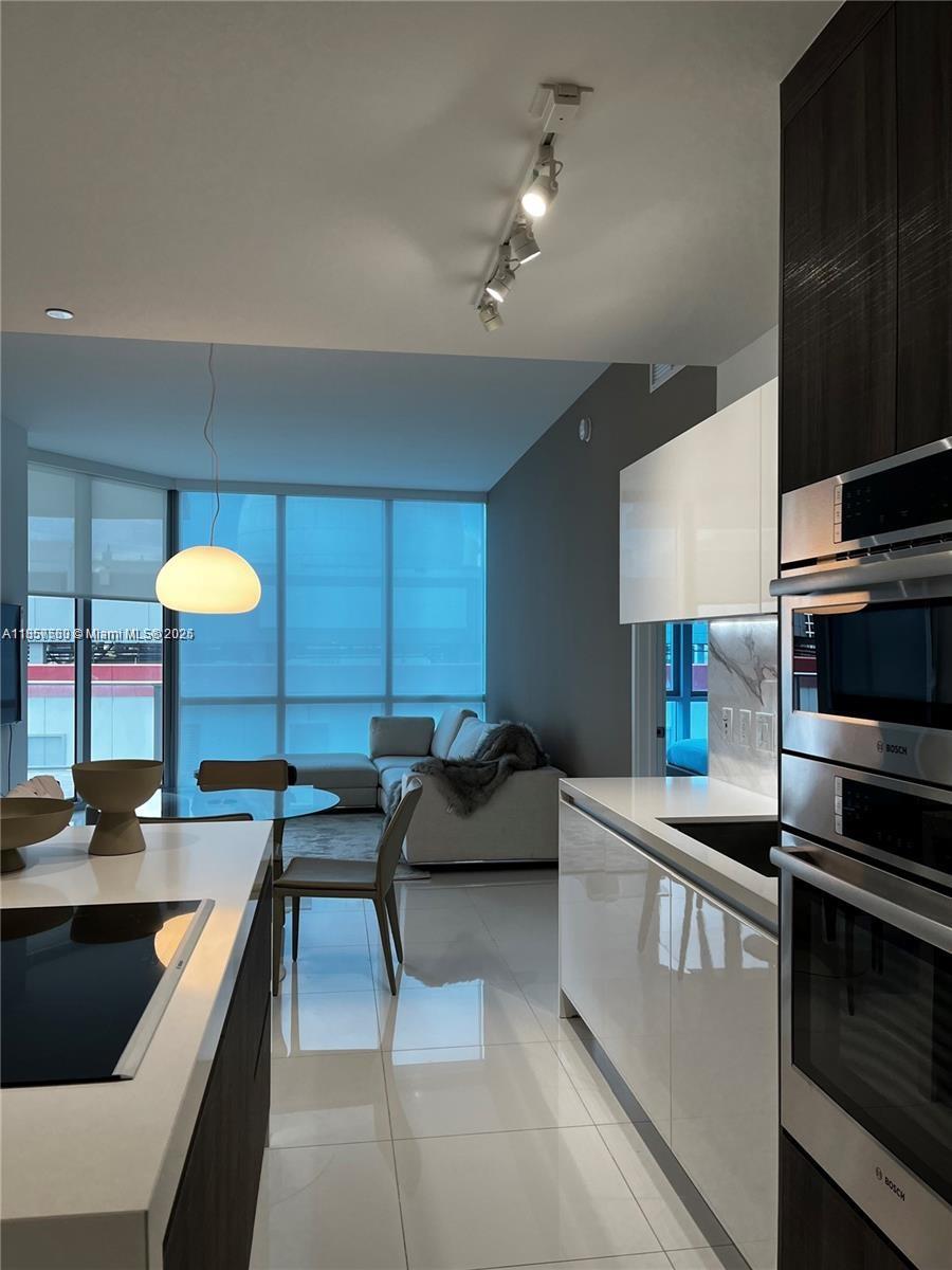851 Northeast 1st Avenue, Unit 808 Miami, FL 33132 - Photo 5 of 23 a kitchen with stainless steel appliances granite countertop a sink and a stove