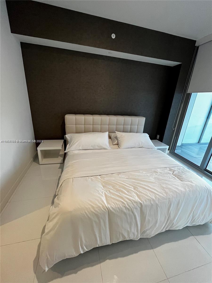 851 Northeast 1st Avenue, Unit 808 Miami, FL 33132 - Photo 10 of 23 a bedroom with a bed and a black white wall