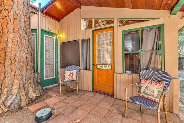 a view of a house with large windows and a tree