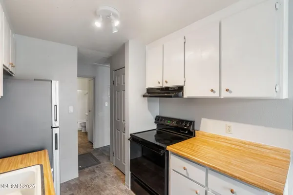 a kitchen with stainless steel appliances granite countertop a stove a refrigerator and a white cabinets