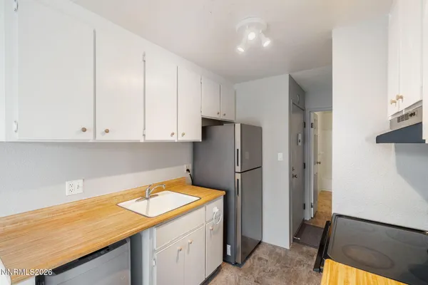 a kitchen with a refrigerator sink and cabinets